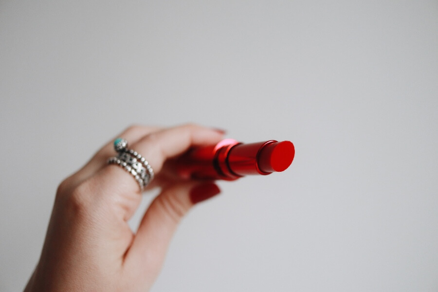 woman holding a red lipstick