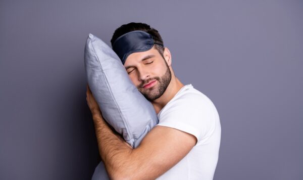 Κοντινό πορτρέτο ενός ωραίου ελκυστικού γενειοφόρου άνδρα που κρατάει το μαξιλάρι του και πάει για ύπνο